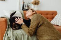 Kaboompics - Woman Cuddling Her Small Dog on a Cognac Leather Couch at Home