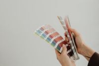 Kaboompics - Hands Comparing Color Swatch Fans for Interior Palette