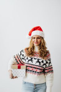 Kaboompics - Smiling Woman in Santa Hat Holding Wrapped Christmas Gifts