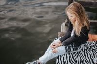 Kaboompics - Blonde woman having a healthy snack at the wooden pier