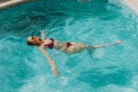 Kaboompics - A beautiful woman in a pool with an inflatable ring