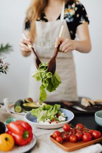 Kaboompics - Close-Up of Lettuce Lifted over a Salad Bowl with Wooden Servers