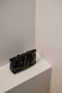 Kaboompics - Black Ruched Leather Handbag on White Shelf