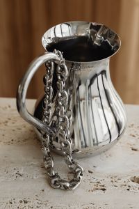 Kaboompics - Silver Chain Draped Over a Metal Pitcher