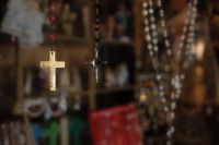 Kaboompics - Gold-Tone Cross Pendant Hanging Among Religious Shop Rosaries