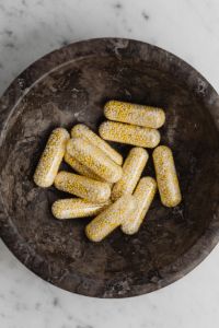 Kaboompics - Bead-Filled Capsules in a Dark Bowl on Marble