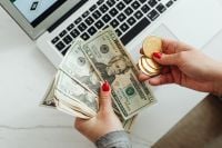 Kaboompics - Hand Holding US Dollar Bills and Bitcoin Coin by Laptop
