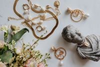 Kaboompics - Gold jewellery in white marble - flowers and a small sculpture, a shell