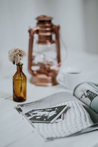 Kaboompics - Magazine with a paraffin lamp on a white table