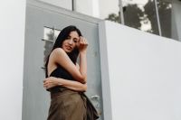 Kaboompics - Asian Woman Touching Her Face in Black Top and Brown Wrap Skirt by Modern Door