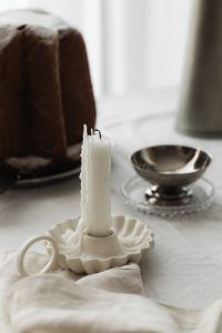 Kaboompics - Close Up White Taper Candle with Panettone and Silver Bowl
