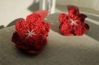 Kaboompics - Macro Detail of Textured Red Crochet Flowers on Sandals Against Gray Upholstery