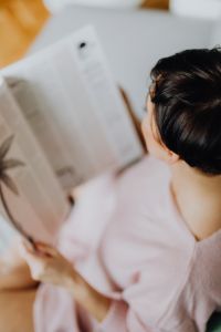 Kaboompics - A woman with short dark hair reads a newspaper