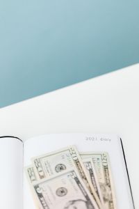 Kaboompics - Open 2021 Diary and Cash Against a Pale Blue Background