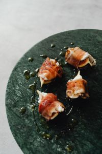 Kaboompics - Prosciutto-Wrapped Figs On Dark Green Slate Plate