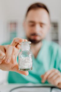 Kaboompics - Doctor Presenting Bottle Filled With Tablets