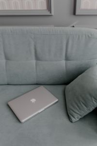 Kaboompics - MacBook laptop lying on mint couch