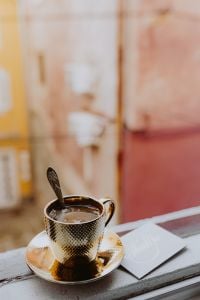 Kaboompics - Drink coffee in a golden cup at the window