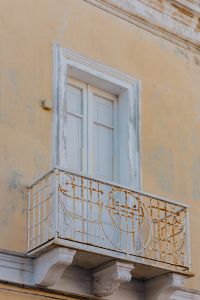 Kaboompics - Rusted Wrought-Iron Balcony on a Faded Mediterranean Facade