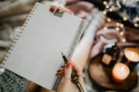 Kaboompics - Writing in a notebook lying in bed, with coffee, candles, and gingerbreads