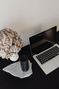 Kaboompics - Close-Up Black Candle and Laptop with Dried Hydrangeas on Marble, Home Office Detail