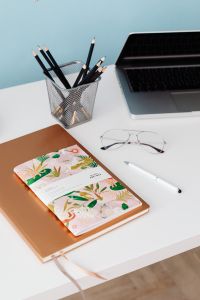 Kaboompics - White Desk Lamp, Eyeglasses and Illustrated Notebook
