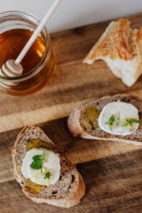 Kaboompics - Honey Dipper Beside Fresh Baguette and Goat Cheese