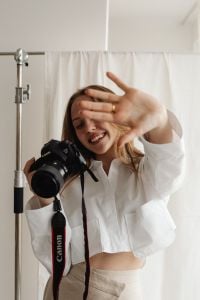 Kaboompics - Young Female Content Creator Reaching Toward Camera with DSLR