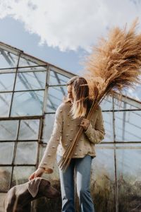 Kaboompics - Side Portrait of Woman Carrying Pampas Grass beneath Blue Sky