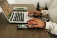 Kaboompics - Using Smartphone And Laptop Remote Work Desk