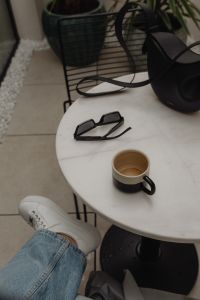 Kaboompics - Coffee Break on Covered Patio With Sunglasses and Black Leather Handbag