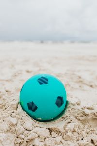 Kaboompics - Soft-Focus Turquoise Beach Ball Against a Quiet Shoreline for Travel Layouts