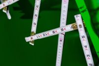 Kaboompics - Extandable wooden ruler on a green background