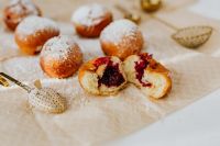 Kaboompics - Cherry-Filled Polish Paczki Cut Open in a Flat Lay with Sugar-Dusted Doughnuts