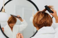 Kaboompics - Close-Up of a Woman Using a Flat Iron to Smooth Short Brown Hair