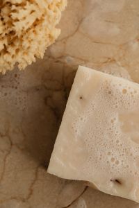 Kaboompics - White Soap Bar and Natural Sea Sponge on Wet Stone