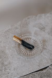 Kaboompics - Palo Santo Stick on Clear Glass Dish with Marble Texture, Minimal Wellness Still Life