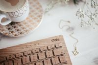 Kaboompics - Wooden Keyboard and Coffee with Necklace and Baby’s Breath