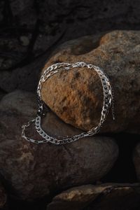Kaboompics - Silver Chain Necklace on Dark Malta Beach Rocks