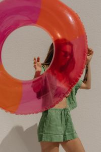 Kaboompics - Woman Posing Behind a Pink Inflatable Ring in Green Beachwear