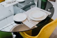 Kaboompics - Round Glass Dining Table with Colorful Chairs in Modern Apartment Interior
