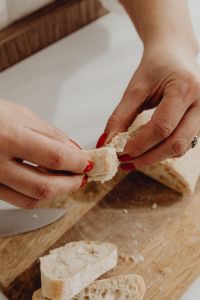 Kaboompics - Close-Up of Hands Tearing Rustic Bread