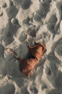 Kaboompics - Brown Bikini Top Flat Lay on Textured Sand