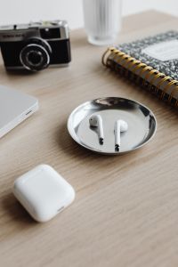 Kaboompics - Camera, Notebook and AirPods on Wooden Desk