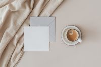 Kaboompics - Neutral Stationery Flat Lay with Blank Card, Envelope and Coffee on Draped Fabric