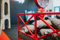Kaboompics - Red Metal Bed Frame and Gray Cushions beneath a Vintage Exhibition Weighing Scale