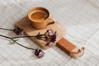 Kaboompics - Coffee Cup and Burgundy Astrantia on a Wooden Board over Textured Linen