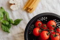 Kaboompics - Cherry Tomatoes, Basil and Garlic in a Black Colander