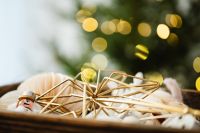 Kaboompics - Neutral Christmas Ornaments in a Box with Tree Bokeh