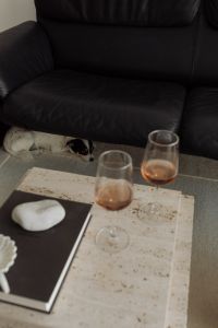 Kaboompics - Black Leather Sofa with Open Book and Travertine Tables